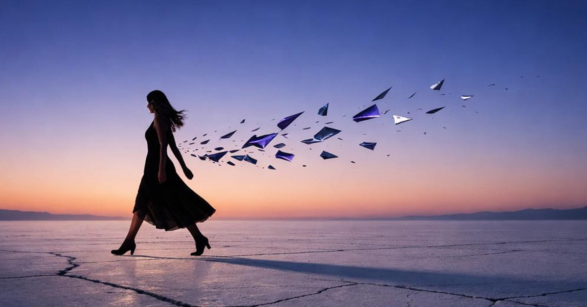 Nourivra Co. She Moves Different now- woman walking leaving a trail behind on dry cracked ground at sunset- crescent moon