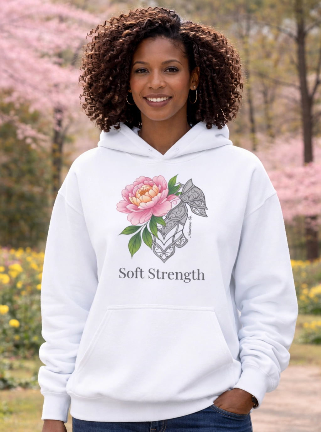  African American woman wearing Nourivra Co. original colored graphic design of Soft Strength on white t-shirt 